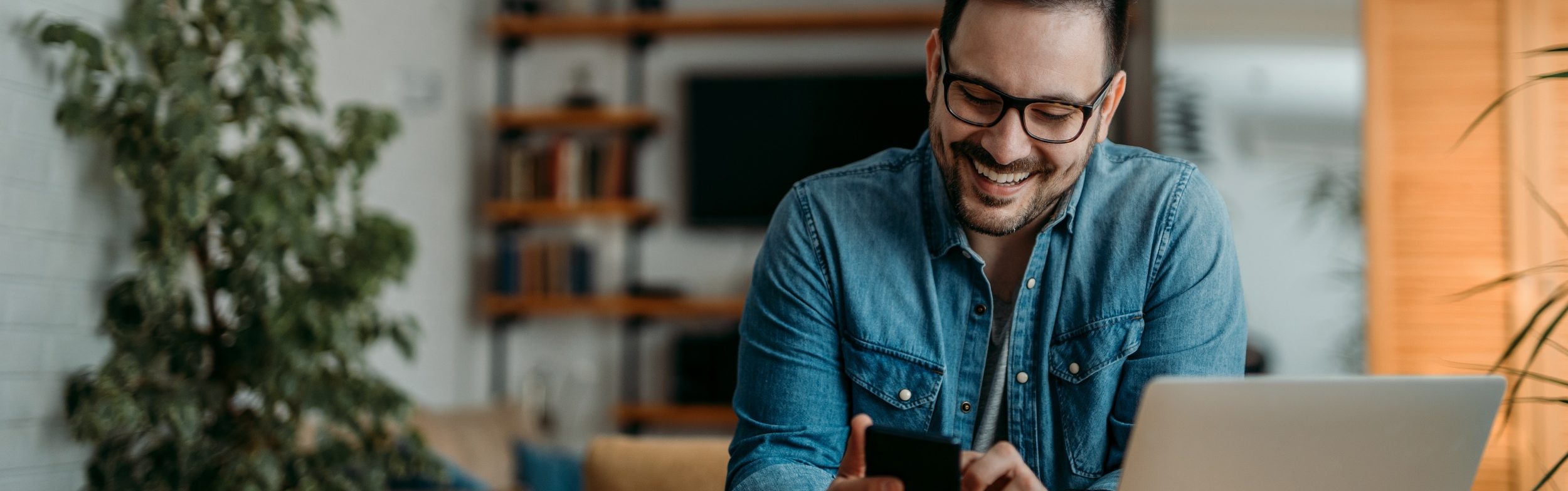 Portrait of a cheerful man using smart phone at home office. Portrait of a cheerful man using smart phone at home office.