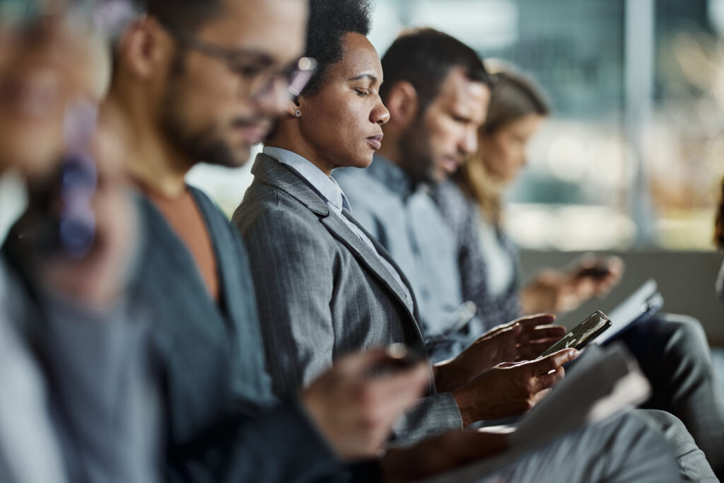 Black businessman using smart phone on a seminar in board room