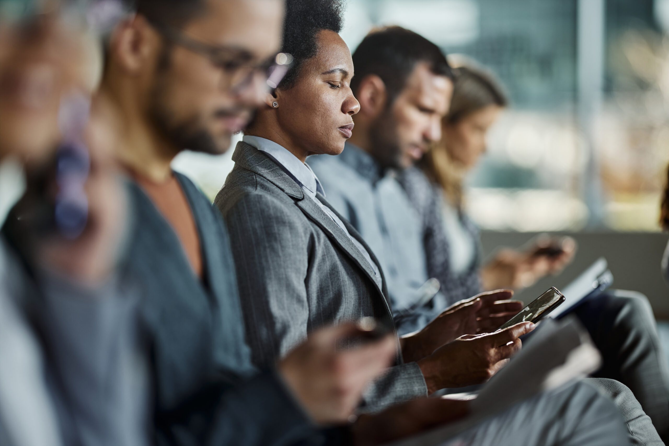 Black businessman using smart phone on a seminar in board room