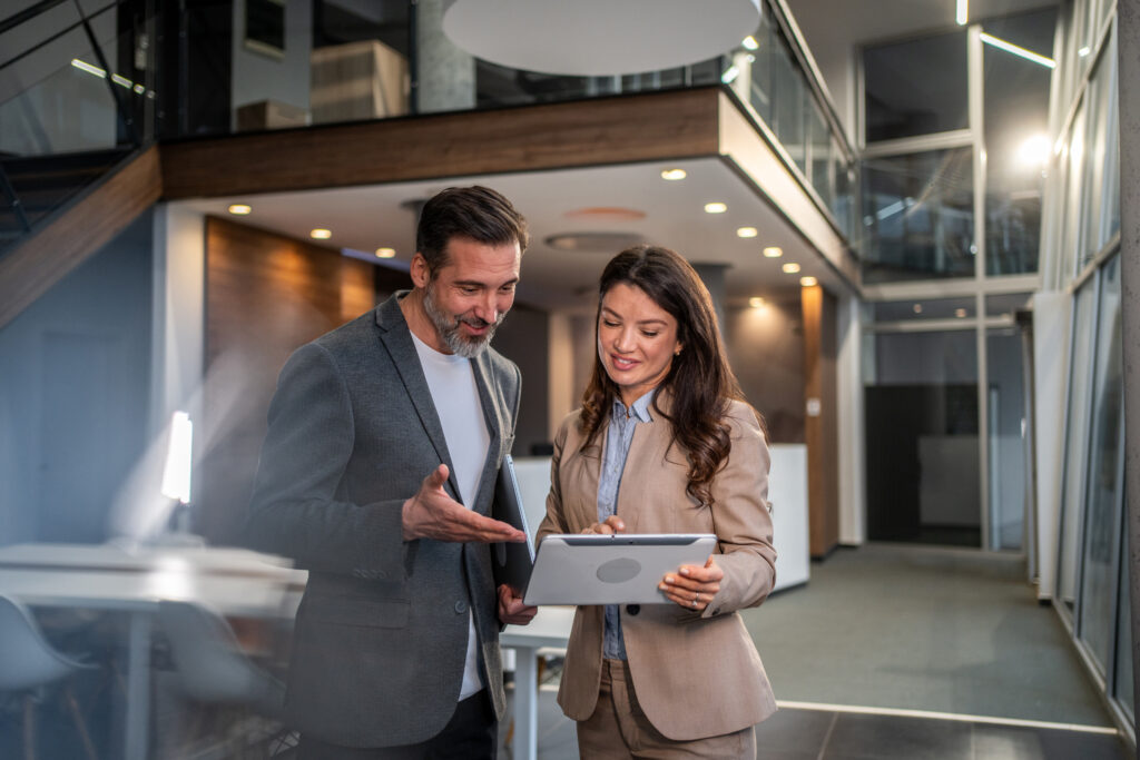 Business colleagues collaborating on digital tablet in modern office